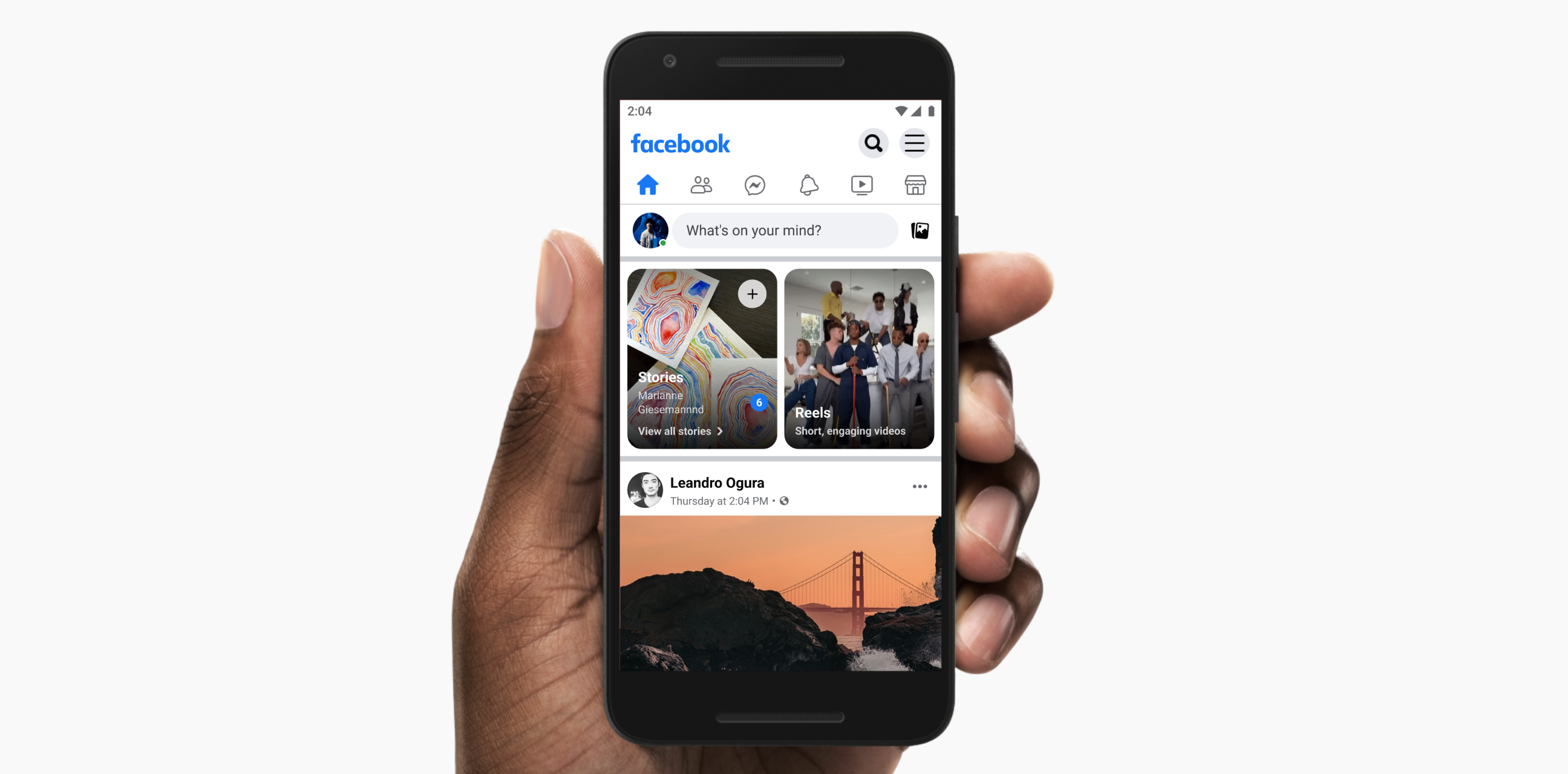 A hand holding a phone showing the Facebook feed with the Stories tray at the top